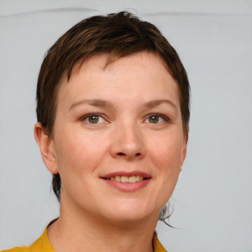 Joyful white young-adult female with short  brown hair and grey eyes