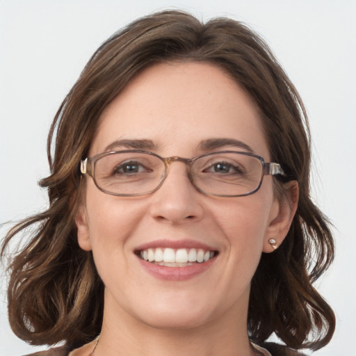 Joyful white adult female with medium  brown hair and blue eyes