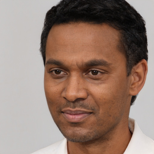 Joyful latino adult male with short  black hair and brown eyes