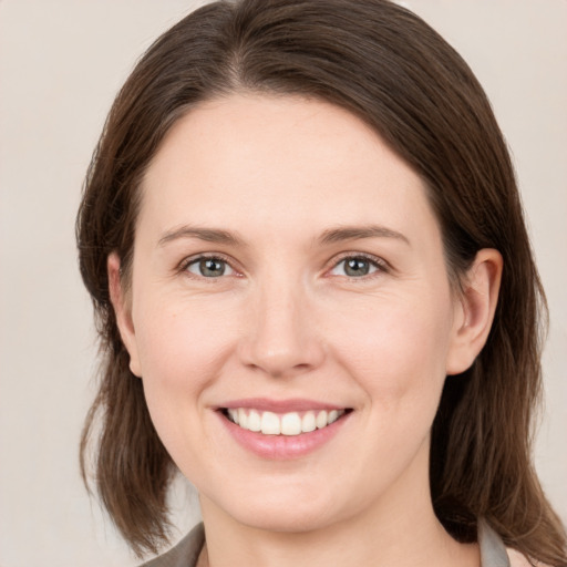 Joyful white young-adult female with medium  brown hair and grey eyes