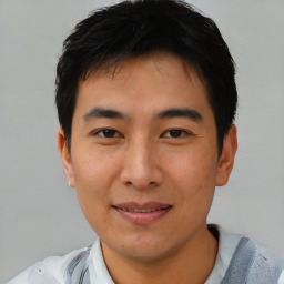 Joyful asian young-adult male with short  black hair and brown eyes