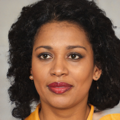 Joyful black young-adult female with medium  black hair and brown eyes