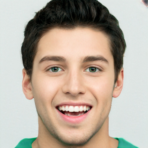 Joyful white young-adult male with short  brown hair and green eyes