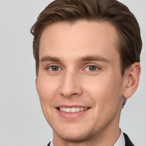 Joyful white young-adult male with short  brown hair and grey eyes