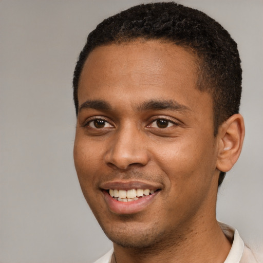 Joyful black young-adult male with short  brown hair and brown eyes