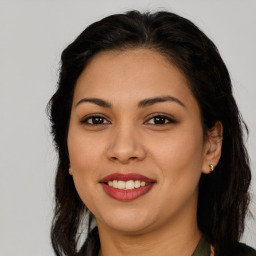 Joyful latino young-adult female with long  brown hair and brown eyes