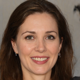 Joyful white adult female with long  brown hair and brown eyes