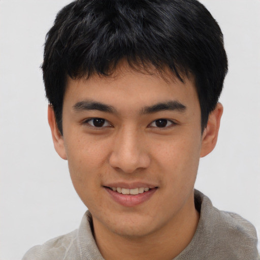 Joyful asian young-adult male with short  brown hair and brown eyes