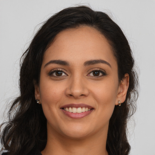 Joyful latino young-adult female with long  brown hair and brown eyes