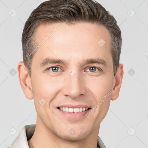 Joyful white young-adult male with short  brown hair and grey eyes