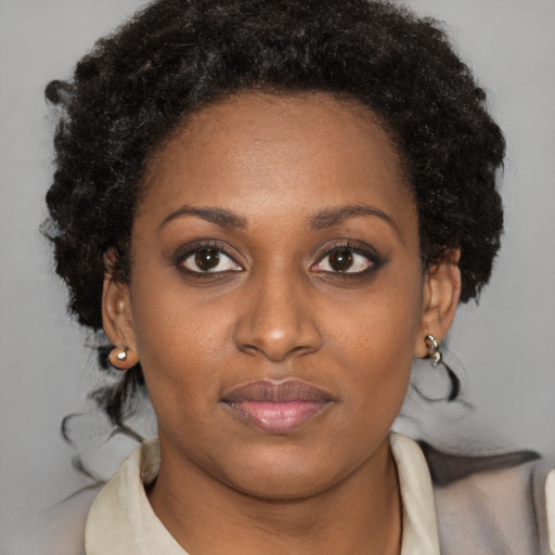 Joyful black young-adult female with short  brown hair and brown eyes