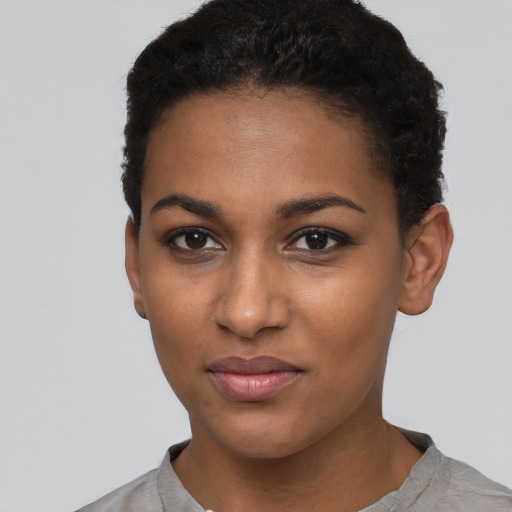 Joyful black young-adult female with short  black hair and brown eyes