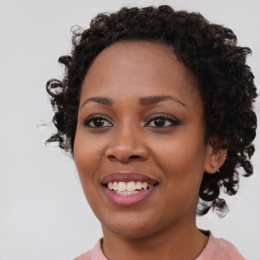 Joyful black young-adult female with medium  brown hair and brown eyes