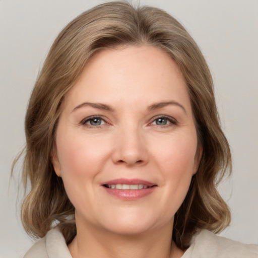 Joyful white adult female with medium  brown hair and brown eyes