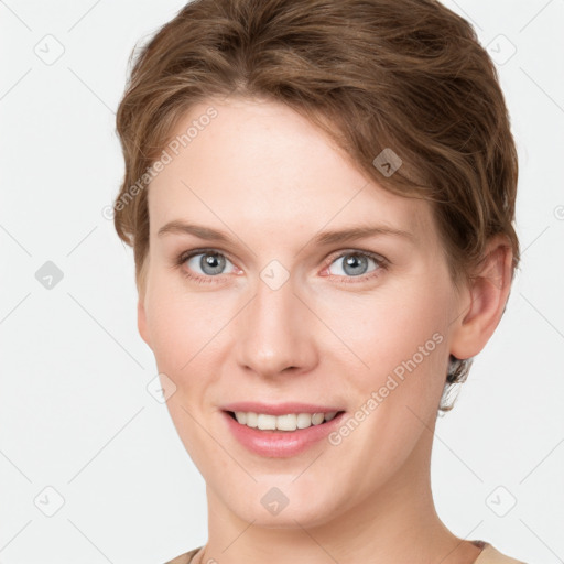 Joyful white young-adult female with short  brown hair and grey eyes