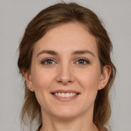 Joyful white young-adult female with medium  brown hair and grey eyes