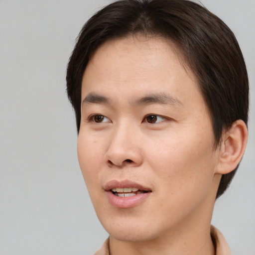 Joyful asian young-adult male with short  brown hair and brown eyes