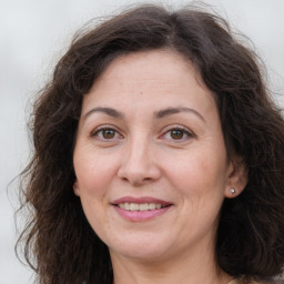 Joyful white adult female with long  brown hair and brown eyes