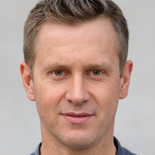 Joyful white adult male with short  brown hair and grey eyes