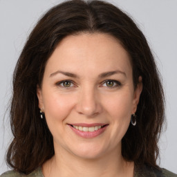 Joyful white young-adult female with medium  brown hair and green eyes