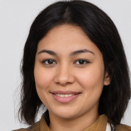 Joyful latino young-adult female with medium  brown hair and brown eyes