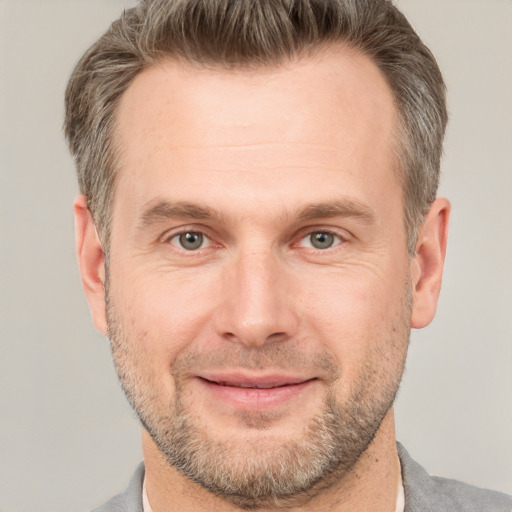 Joyful white adult male with short  brown hair and grey eyes