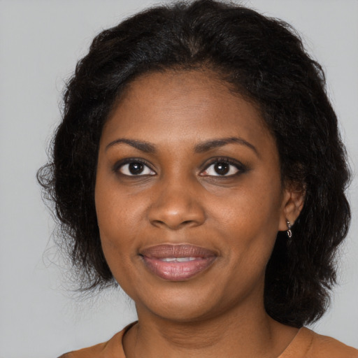 Joyful black young-adult female with long  brown hair and brown eyes