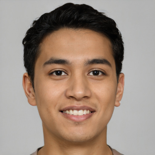Joyful latino young-adult male with short  black hair and brown eyes