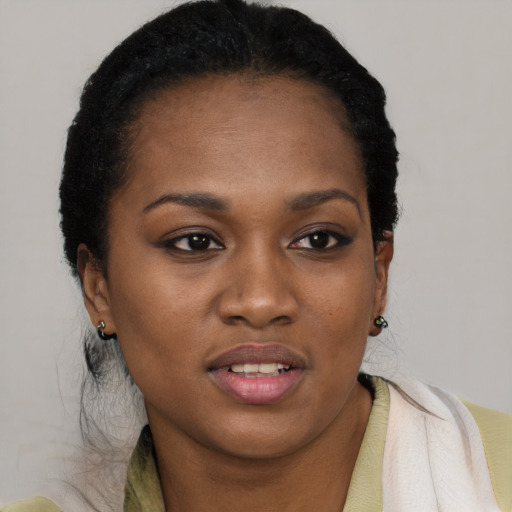 Joyful black young-adult female with short  black hair and brown eyes