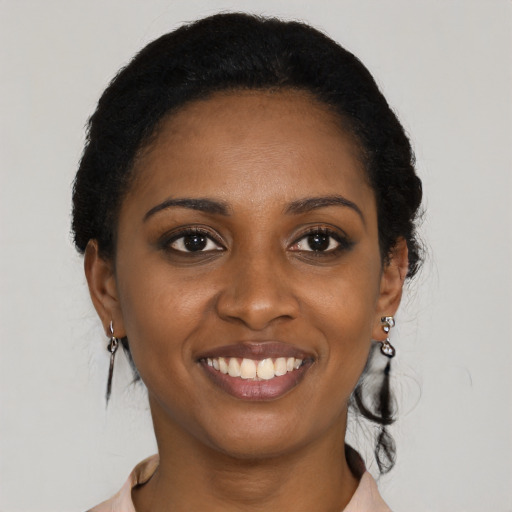 Joyful black young-adult female with long  black hair and brown eyes