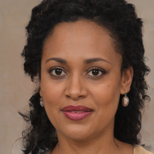 Joyful black adult female with long  brown hair and brown eyes