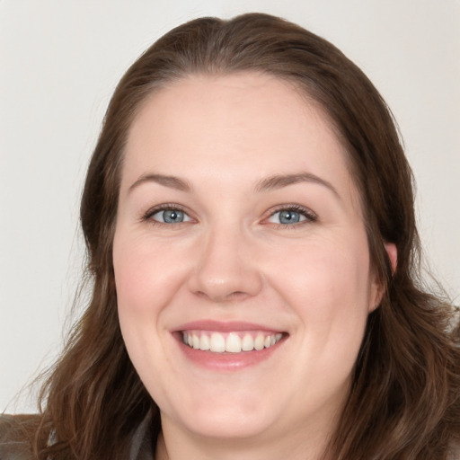 Joyful white young-adult female with long  brown hair and blue eyes