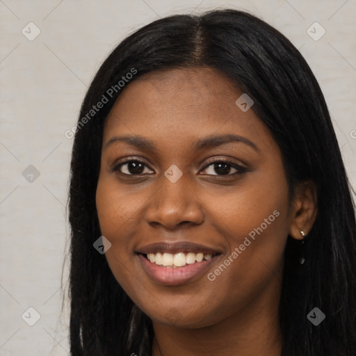 Joyful black young-adult female with long  black hair and brown eyes