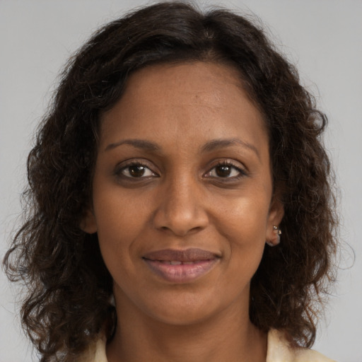 Joyful black adult female with medium  brown hair and brown eyes