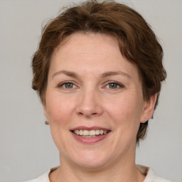 Joyful white adult female with medium  brown hair and grey eyes