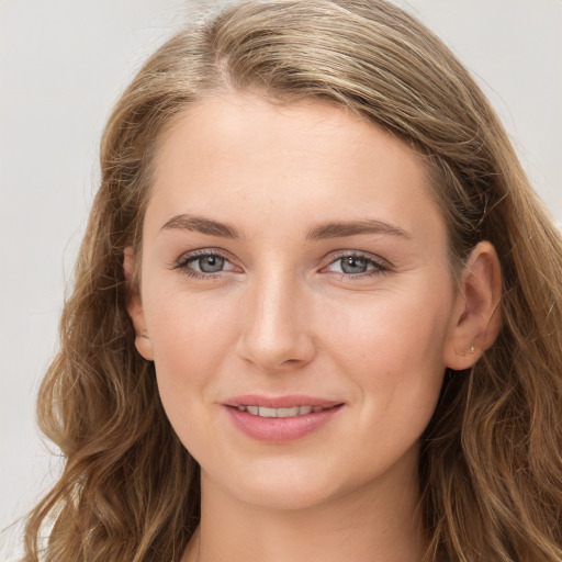 Joyful white young-adult female with long  brown hair and blue eyes