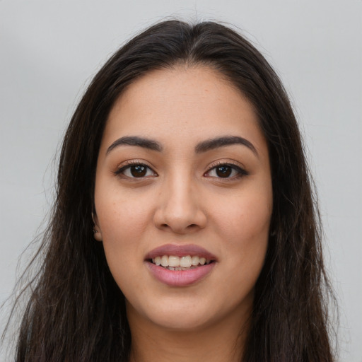 Joyful latino young-adult female with long  brown hair and brown eyes