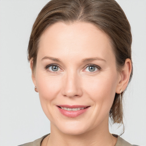 Joyful white young-adult female with medium  brown hair and grey eyes