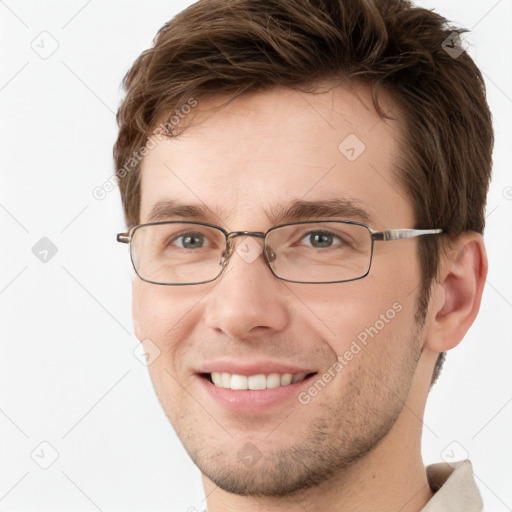 Joyful white young-adult male with short  brown hair and grey eyes