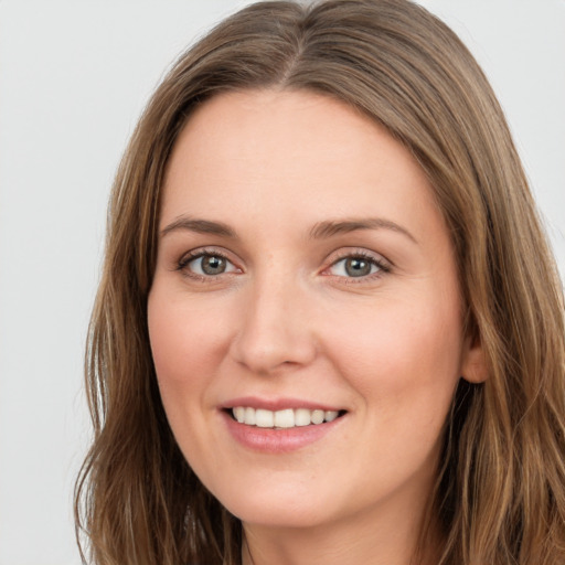 Joyful white young-adult female with long  brown hair and green eyes