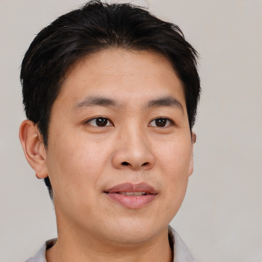 Joyful asian young-adult male with short  brown hair and brown eyes