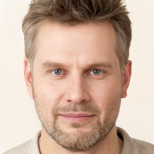 Joyful white adult male with short  brown hair and grey eyes