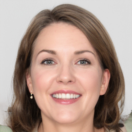 Joyful white adult female with medium  brown hair and green eyes