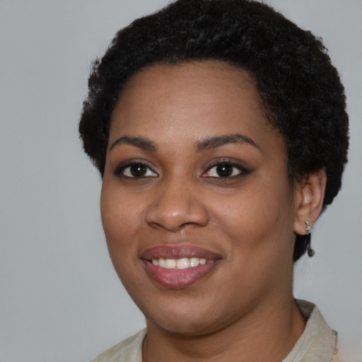 Joyful black young-adult female with short  black hair and brown eyes