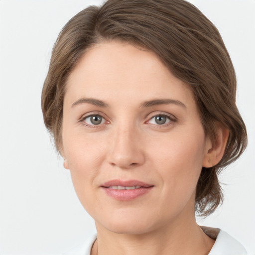 Joyful white young-adult female with medium  brown hair and green eyes