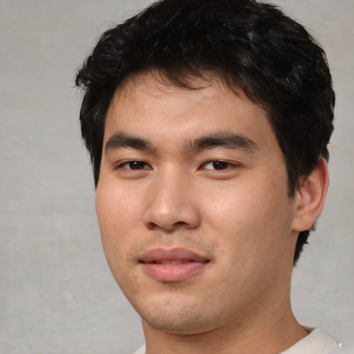 Joyful asian young-adult male with short  black hair and brown eyes