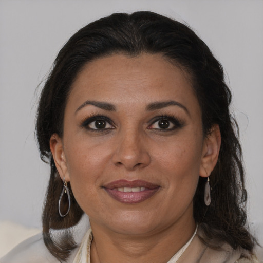 Joyful latino adult female with medium  brown hair and brown eyes