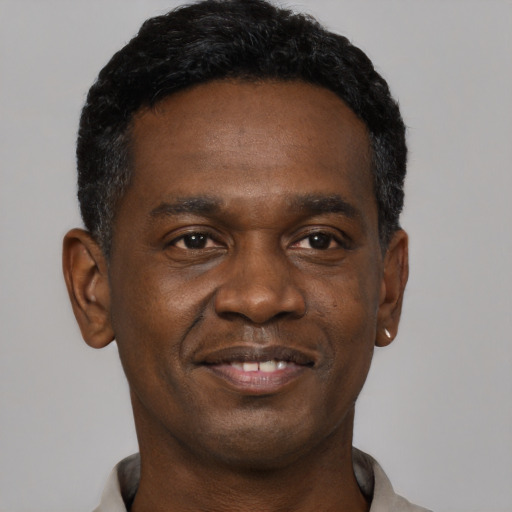 Joyful black young-adult male with short  black hair and brown eyes