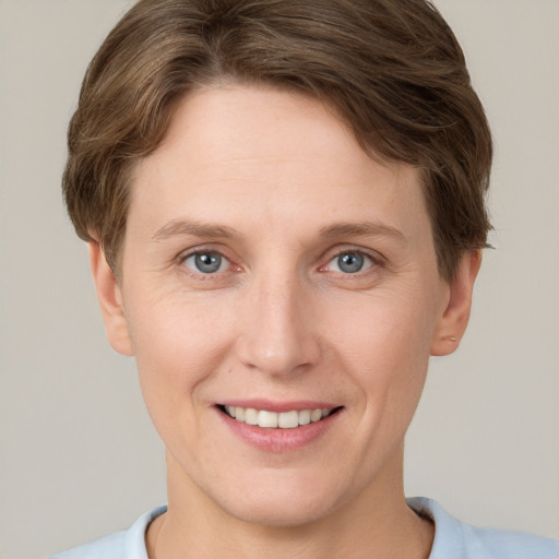 Joyful white young-adult female with short  brown hair and grey eyes