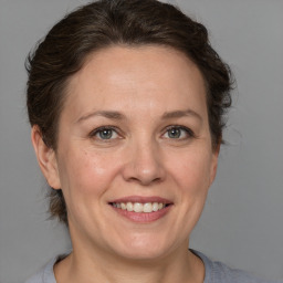 Joyful white adult female with medium  brown hair and grey eyes